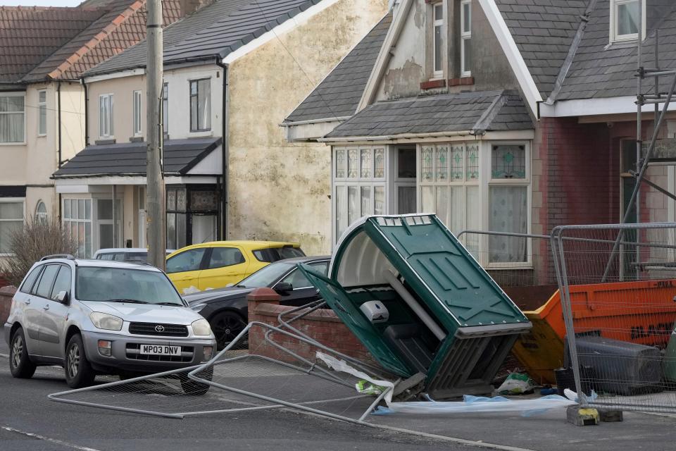 A fence and a mobile toilet blown over by the wind as Storm Eowyn hits the country in Blackpool, England (AP)
