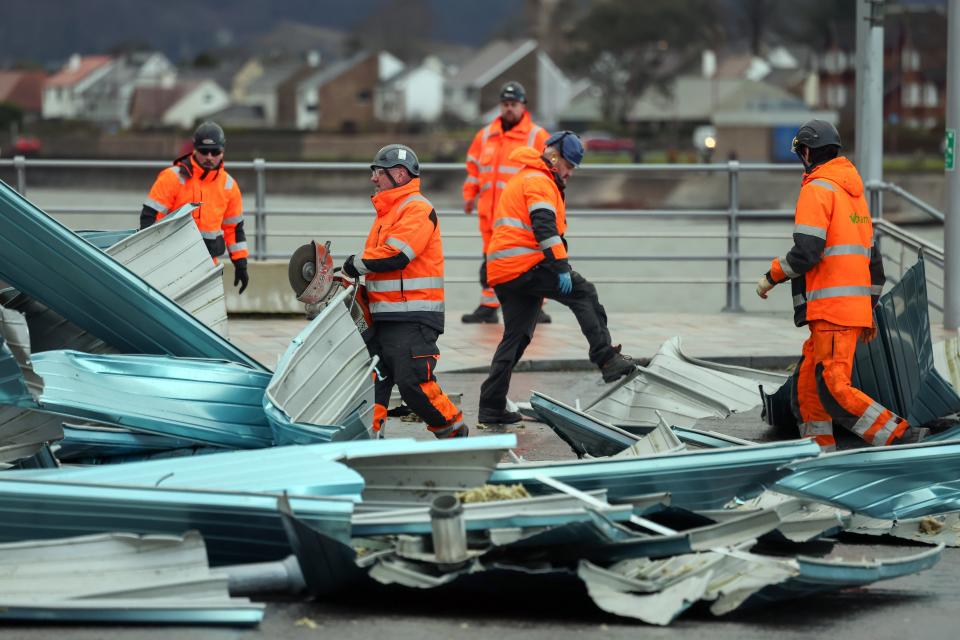 Workers clear debris from the roof blown off a leisure centre during storm Eowyn (Jeff J Mitchell/Getty Images)