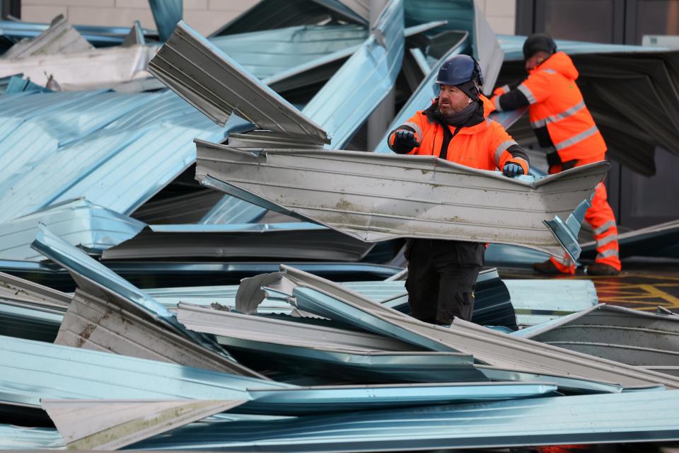 Workers clear debris from the roof blown off a leisure centre during storm Eowyn in Helensburgh, Scotland (Getty Images)