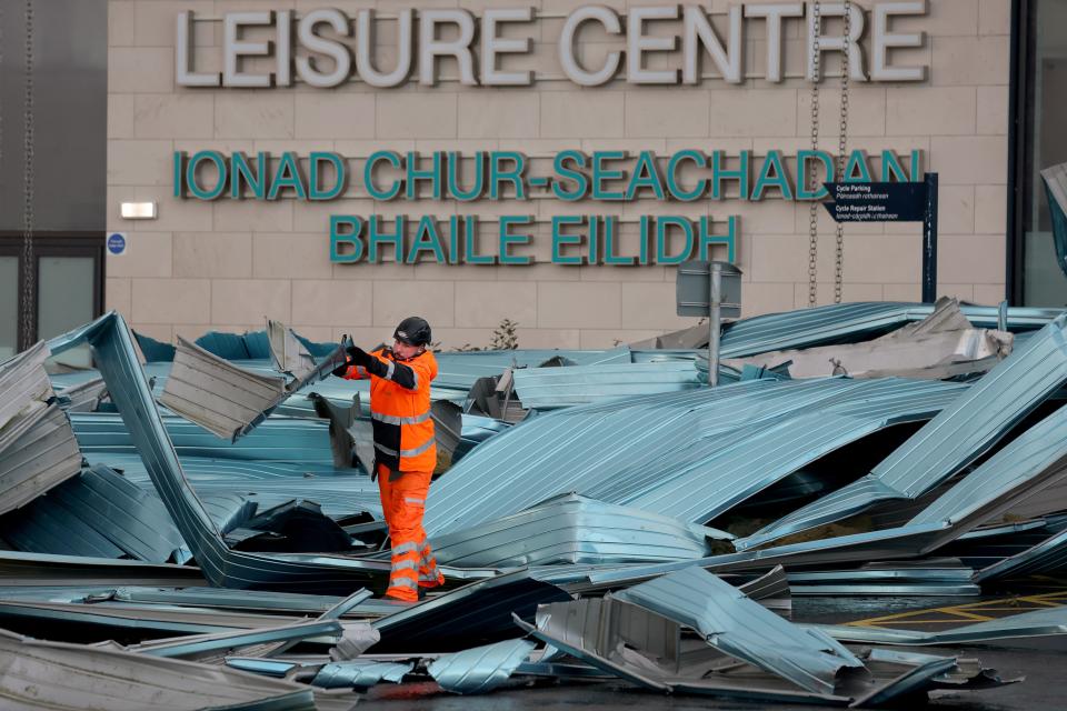 Workers clear debris from the roof blown off a leisure centre during storm Eowyn in Helensburgh, Scotland (Jeff J Mitchell/Getty Images)