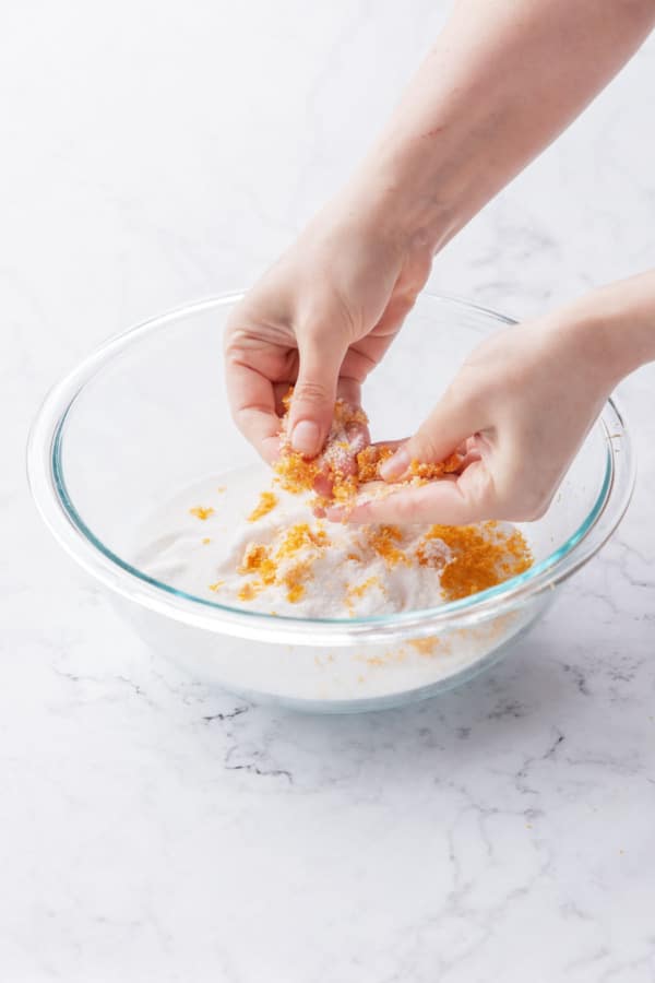 Rubbing grapefruit zest into granulated sugar to release the flavors.