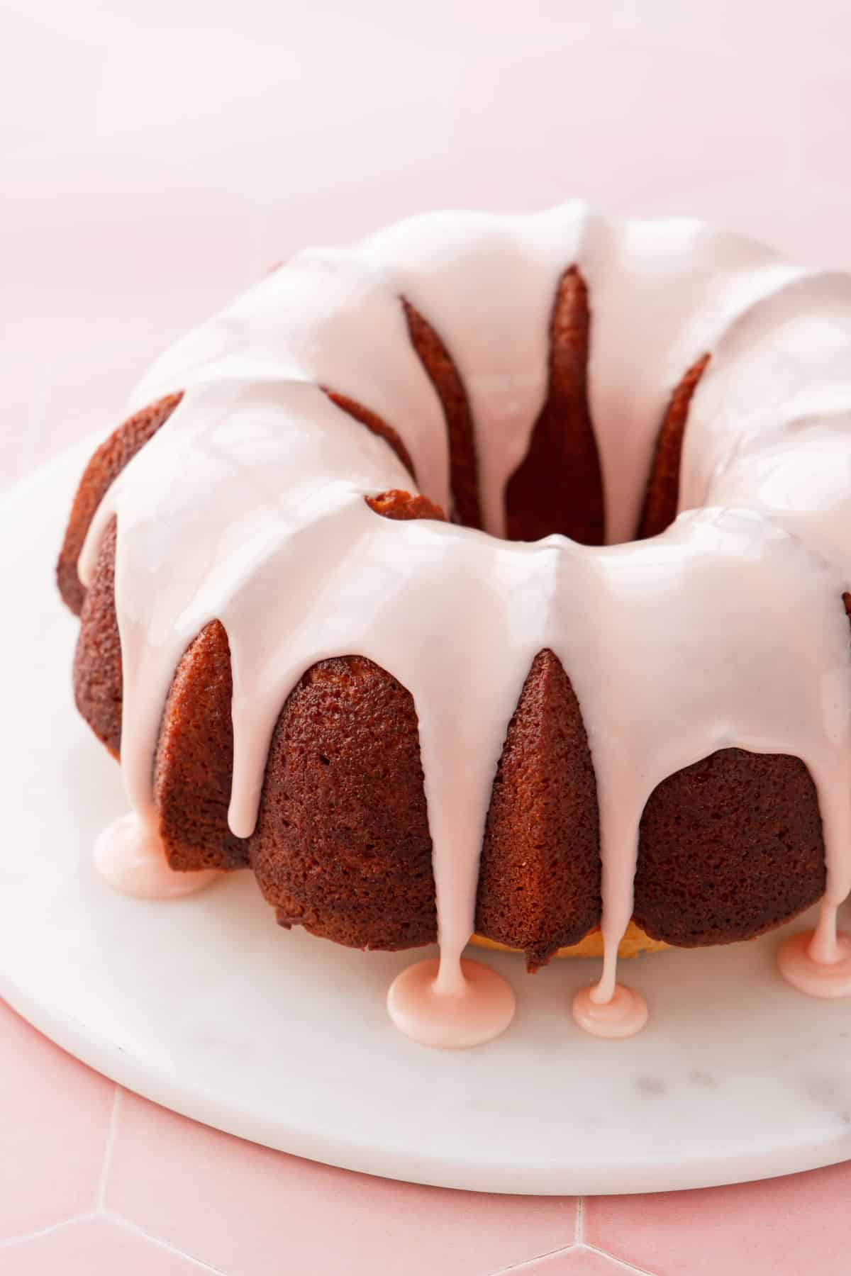 The final glazed grapefruit bundt cake with a perfectly drizzled light pink grapefruit glaze.