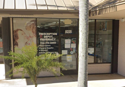 Storefront of Prescription Depot Pharmacy with large front windows displaying text about services offered, a plant in front, and a tree partially obscuring part of the view. The address "8225" is above the entrance.