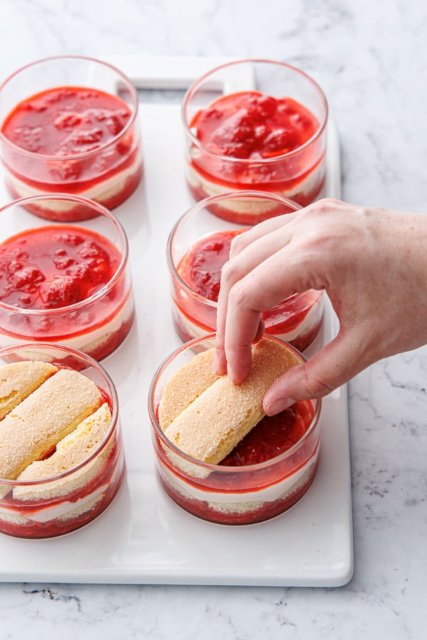 Topping with the last layer of ladyfinger cookies that have been cut into circular shapes.
