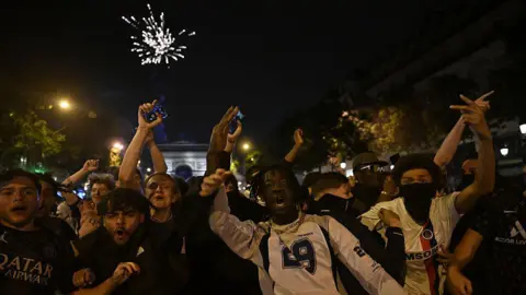 Getty Images A group of celebrating football fans with the Arc de Triomphe visible in the background