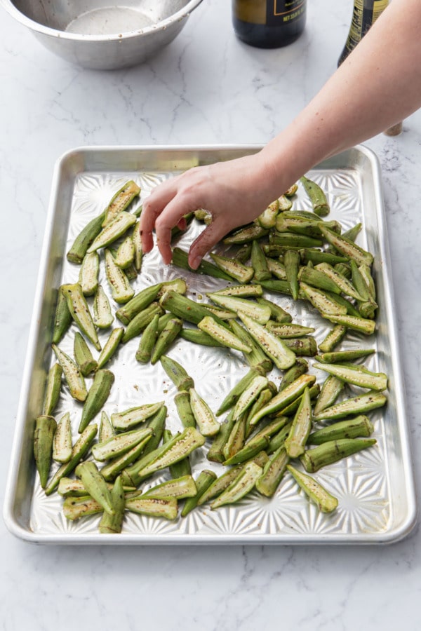 Spreading okra into an even layer and turning the cut sides down.